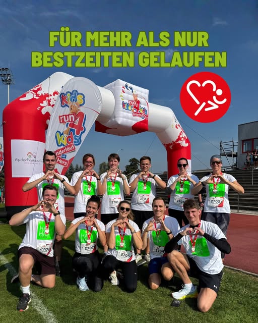 Kids Run 4 Kids-Teilnehmer bilden mit den Händen Herzen vor der aufblasbaren Startbogen-Tor in Wien